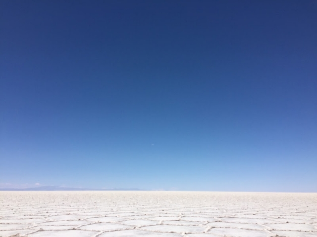 標高の高いウユニ塩湖で、濃い青空と白い塩の大地が広がる風景