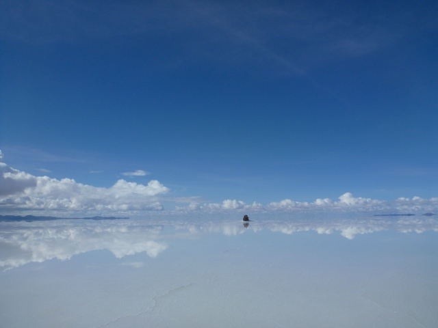 平らな塩の大地に薄く水が広がり、空を映し出すウユニ塩湖の鏡面