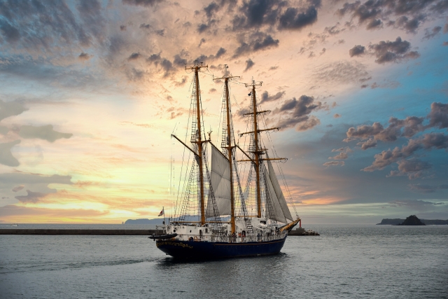 夜明けの海を進む帆船。妄想の旅として描かれる、ある新人水夫の静かな航海を象徴する風景