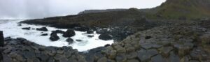 ジャイアンツ・コーズウェーの六角形の石柱と荒波の海岸風景