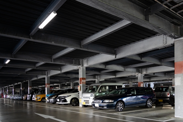柱番号が並ぶ立体駐車場に多くの車が停まる風景。同じ景色が続き、自分の車の場所を見失いやすい駐車場