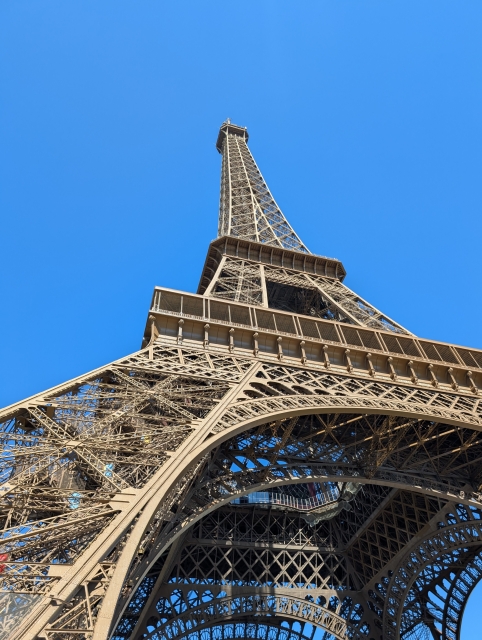 下から見上げたエッフェル塔の鉄骨構造と空へ伸びる近代建築