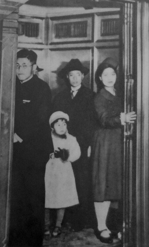 1930年代の日本でエレベーターに乗る人々とエレベーターガールの白黒写真